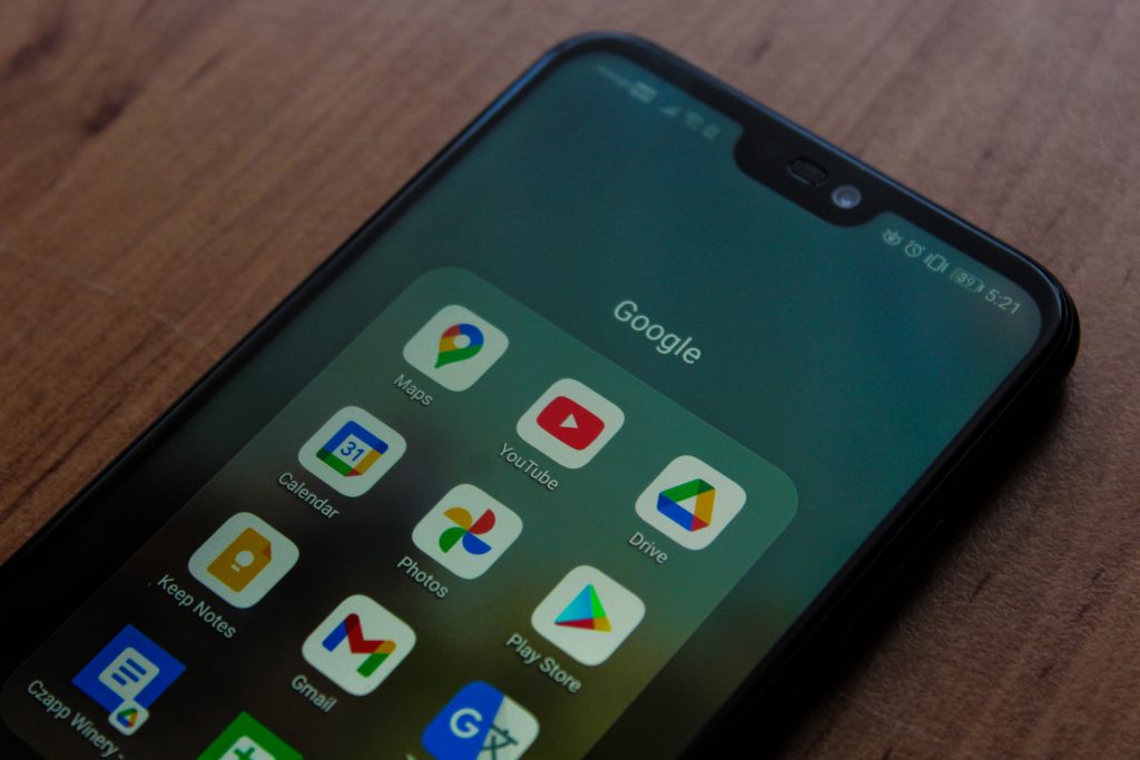 Zu sehen ist ein Smartphone. Auf dem Display ist der App-Unterordner "Google" geöffnet in dem die wichtigsten Google Apps gesammelt sind.